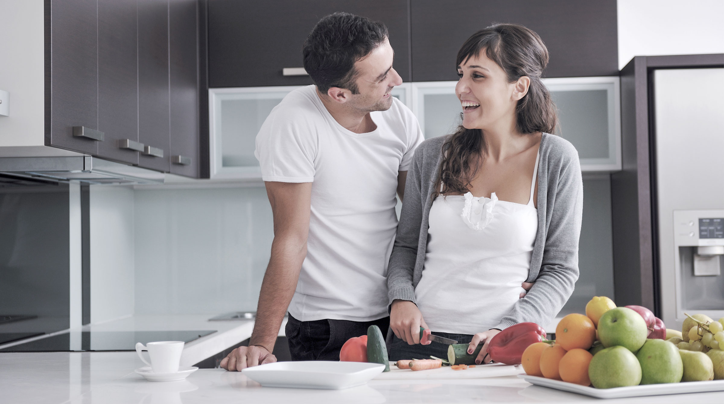 Junges Paar freut sich über die neue Küche, die sie günstig finanziert haben