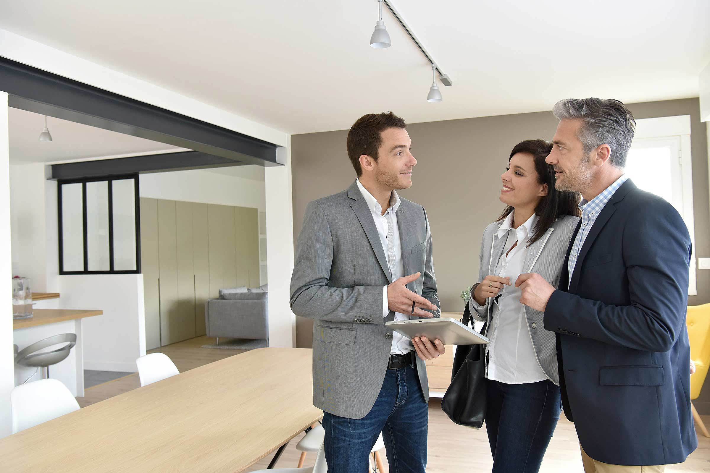 Ein Immobilienmakler berät ein Paar bei der Immobiliensuche