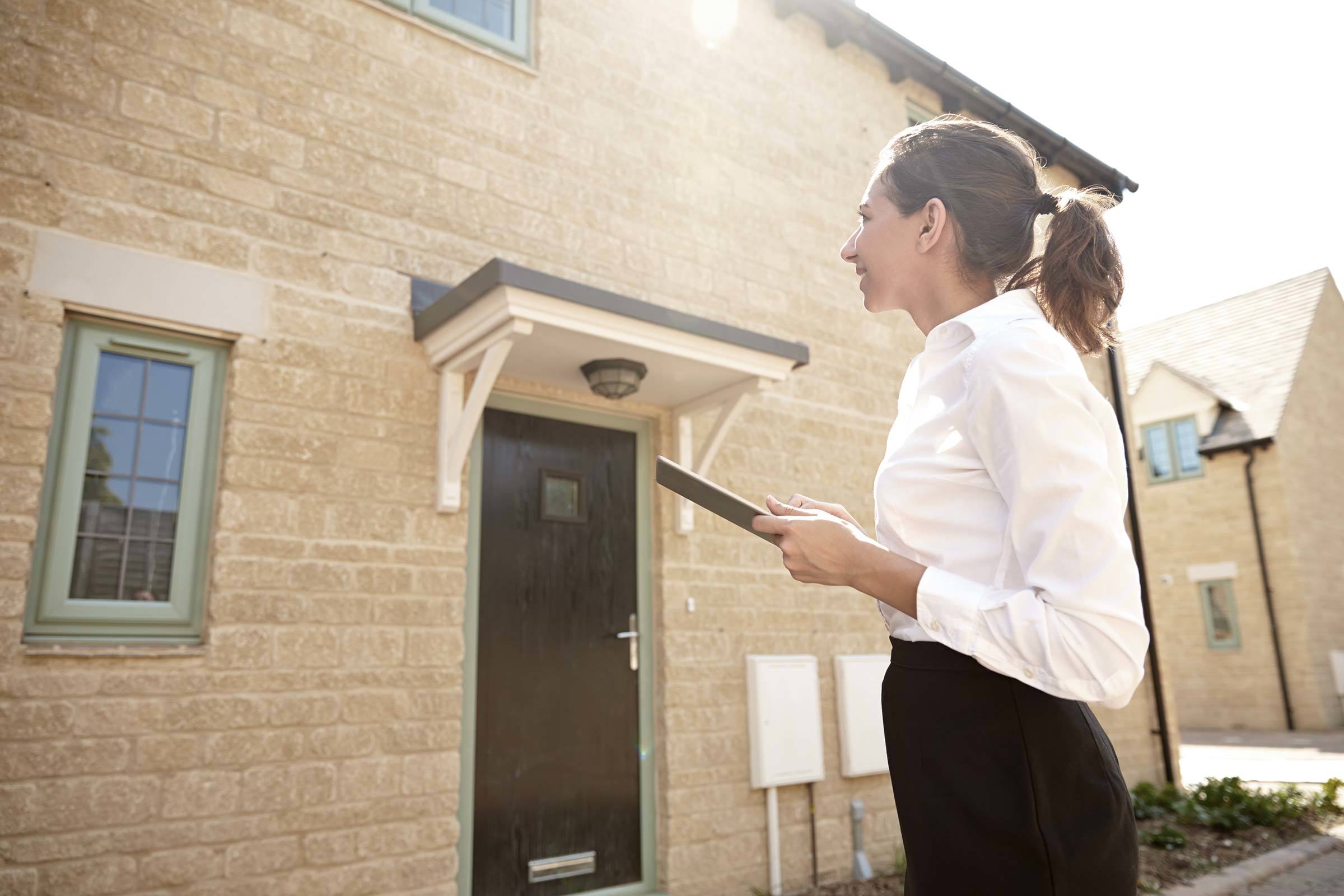 Maklerin schätzt den Immobilienwert eines Hauses