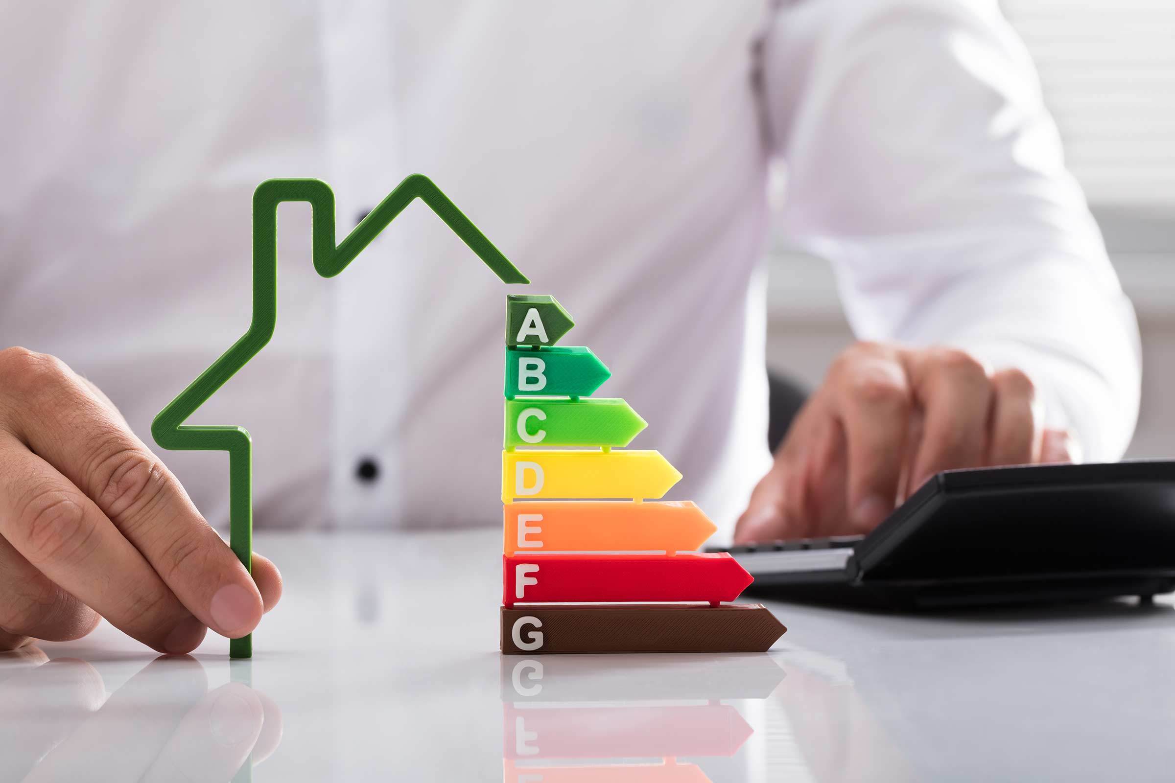 Berater zeigt die verschiedenen Energieeffizienzklassen bei einem Haus