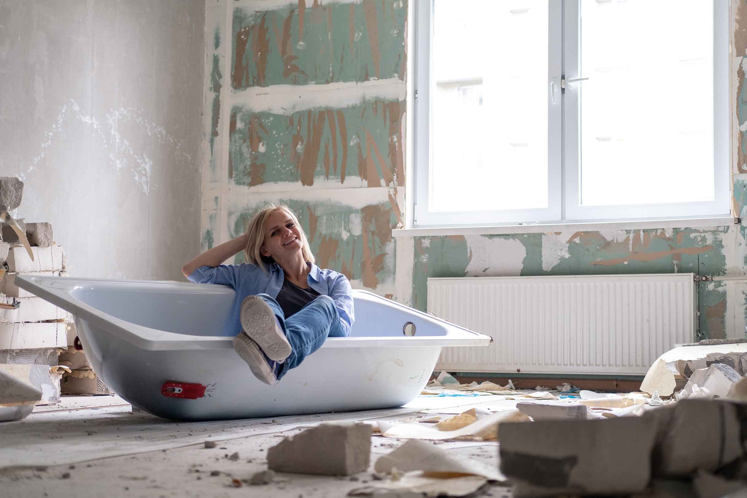 Frau freut sich, mit dem Renovierungskredit bei ihrer Badrenovierung zu sparen